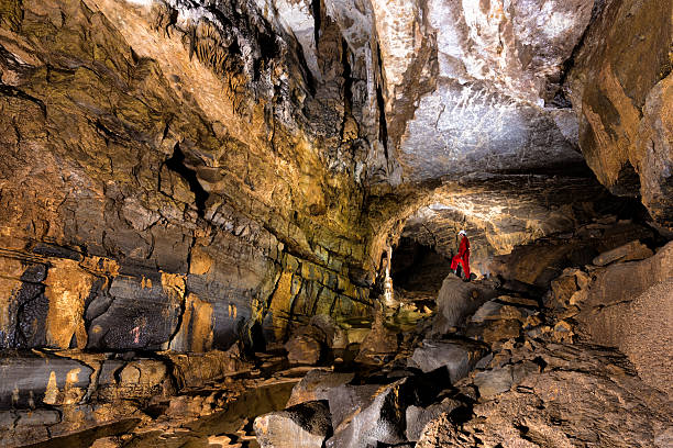 caver posing in the beautiful colorful cave - speleologie buitensport stockfoto's en -beelden