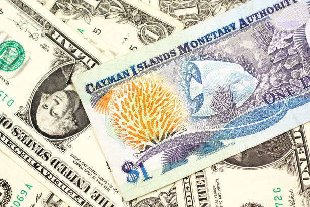 A Cayman Islands dollar bill with American one dollar bills stock photo