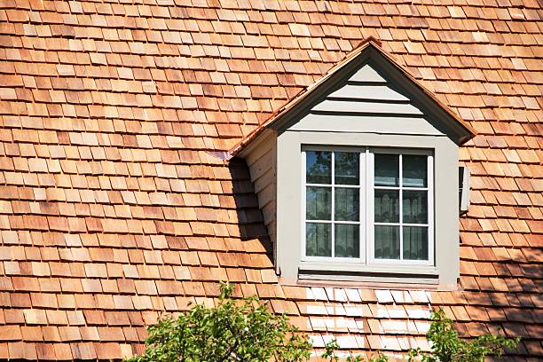 Cedar Dormer Dormer in roof of house with cedar shingles. cedar tree stock pictures, royalty-free photos & images
