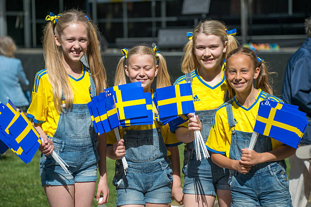 Celebrating the National day of Sweden Norrkoping, Sweden - June 6, 2014: Smiling girls celebrating the National day of Sweden in Norrkoping. The national day of Sweden is celebrated on June 6 annually and is an official holiday. swedish flag photos stock pictures, royalty-free photos & images