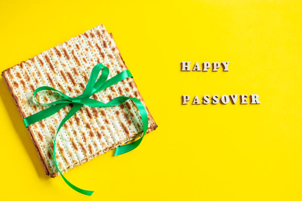 Celebrating the traditional Jewish holiday of Passover. Matzo on a yellow background. Pesach matzah. stock photo