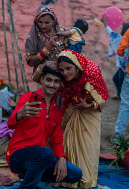Celebration of Chath Puja Ghaziabad, Uttar Pradesh/India - Nov 2019 : Mother and son having selfie post Chhath Puja celebration on Hindon River bank chhath stock pictures, royalty-free photos & images