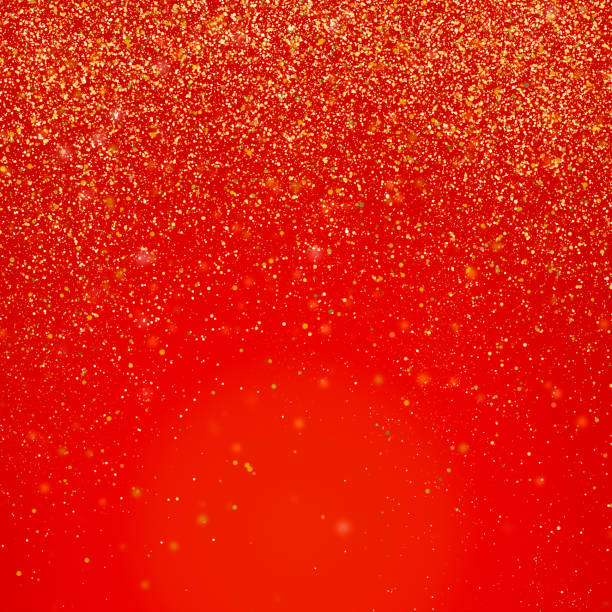Golden glitter falling over red background