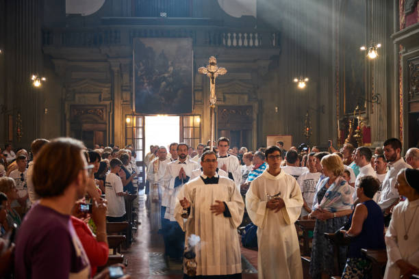 Celebration of Mass in San Firenze Church, Florence, Italy Florence, Italy - April 4 2019: Priests carry the cross through the main nave of church, surrounded by believers catholicism stock pictures, royalty-free photos & images