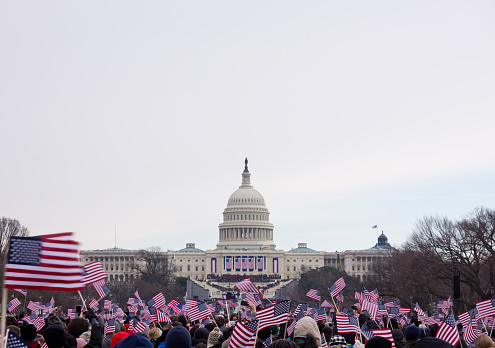 2013 Presidential Inauguration of Barack Obama.  Flag waving spectators throng the Washington Mall near the capital.