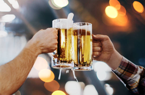 Celebratory toast with pints of beer. stock photo