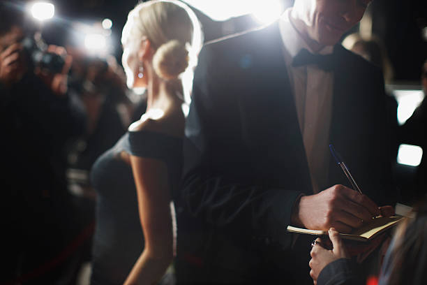 celebrity signing autographs on red carpet - smoking stockfoto's en -beelden