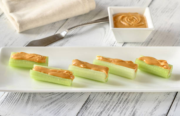 Celery stalks with peanut butter Celery stalks with peanut butter on serving plate celery stock pictures, royalty-free photos & images