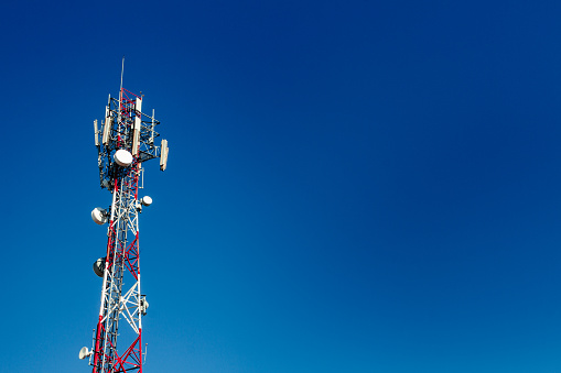 Cell phone antenna tower with blue sky background