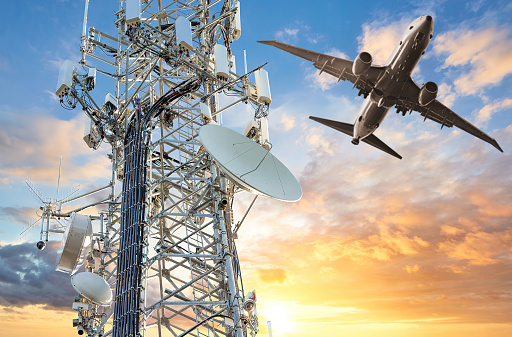 5G Cell tower with airplane flying at sunset. Concept for dangerous altitude interference for landing.