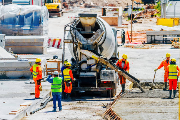 a cement mixer truck pours concrete on a construction site - ready mix imagens e fotografias de stock