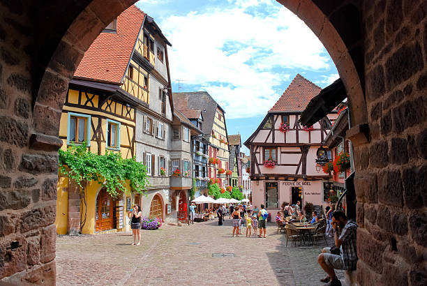 central square in Riquewihr town, France Riquewihr, France - July 11, 2010: group of tourists visits the picturesque central square in Riquewihr town on Wine Road, France. Riquewihr was fortified in 1291 by Lords of Colmar and now town deserves label of "most beautiful villages in France" riquewihr stock pictures, royalty-free photos & images