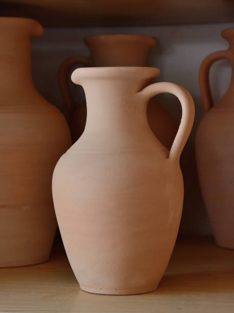 Ceramic craft jug made by a Potter, against the background of other clay products Ceramic craft jug made by a Potter, against the background of other clay products earthenware stock pictures, royalty-free photos & images