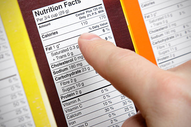 Cereal Nutrition A concerned shopper checks the nutrition labels of various boxes of cereal. fat nutrient stock pictures, royalty-free photos & images