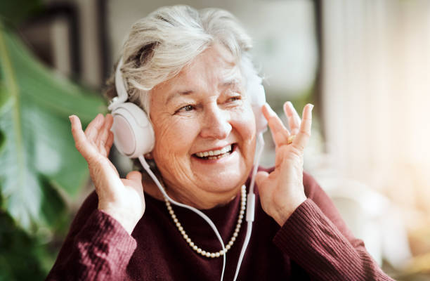Certain memories stay with us forever Shot of happy senior woman listening to music with headphones at a retirement home nostalgia stock pictures, royalty-free photos & images