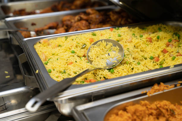 Chaffing Dish with Jollof and Vegetable fried rice at Nigerian Party stock photo