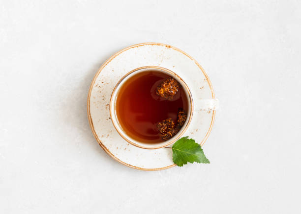 Chaga tea on a white background. Drink with pieces of birch mushroom in a white cup. View from above. Chaga tea on a white background. Drink with pieces of birch mushroom in a white cup. Top view, flat lay. lingzhi stock pictures, royalty-free photos & images
