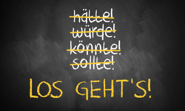 chalkboard with stroked words like could and should and "Let's go" in the middle in German stock photo