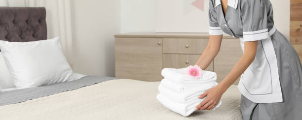 femme de chambre mettant des serviettes propres sur le lit dans la chambre d’hôtel, vue rapprochée avec espace pour le texte. conception de bannière - femme de chambre photos et images de collection