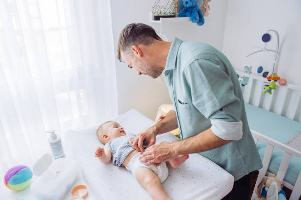 Changing diaper to baby son stock photo