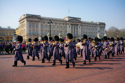 London England - March 25, 2009: Wearing their winter greatcoats tunics, the marching band of the Coldstream Guard march in perfect step away from Buckingham Palace, the London residence of the British Monarch. This is the famous Changing of the Guard.