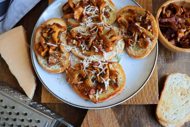 Chanterelle sandwiches with cheese. Open faced sandwich with creamy , seasonings and pepper and herbs on an old wooden background. Mock up. Top view stock photo