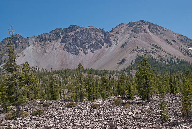 Chaos Crags and Chaos Jumbles The Chaos Crags are a young group of lava domes that formed 1,000 to 1,100 years ago during an instance of Holocene activity. The cluster of domes is located north of Lassen Peak and form the southernmost part of the Cascade Range of mountains. From the base of the Chaos Crags and extending toward the northwest is a rock field known as the Chaos Jumbles. This rock field was formed when the northwest slope of the Chaos Crags was undermined 300 years ago. The resulting avalanche rode on a cushion of compressed air, flattening the forest, damming Manzanita Creek and forming Manzanita Lake. The Chaos Crags are located southeast of Manzanita Lake in Lassen Volcanic National Park, California, USA. jeff goulden lassen volcanic national park stock pictures, royalty-free photos & images