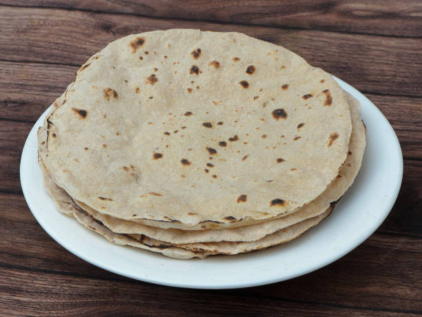 Chapati, isolated over a rustic wooden background, selective focus Chapati, isolated over a rustic wooden background, selective focus chapatti stock pictures, royalty-free photos & images