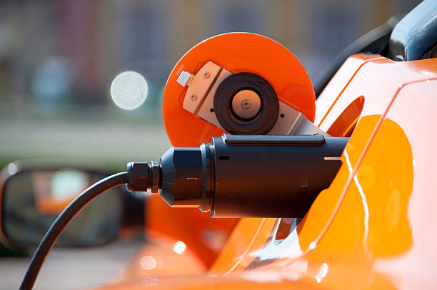 charge orange electric car electric car model charging electric plug photos stock pictures, royalty-free photos & images