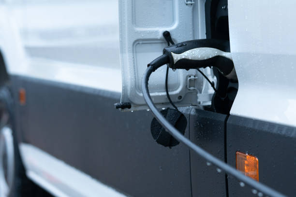 Charging electric van in the rain stock photo