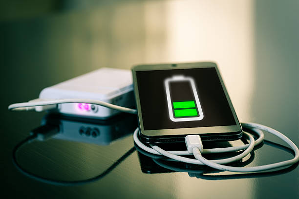 Charging of mobile smartphone Charging of mobile smartphone high quality and high resolution studio shoot battery charger stock pictures, royalty-free photos & images