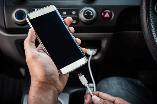 charging smart phones in the car - car charger imagens e fotografias de stock