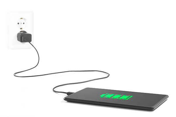 Charging tablet Connection. Tablet is charging from the power outlet on white background. battery charger stock pictures, royalty-free photos & images