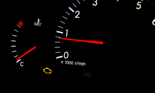 Check engine warning light glowing orange on a dark dashboard.