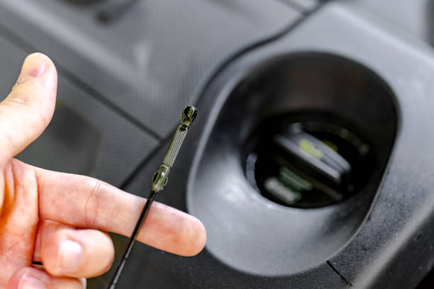 Checking car engine motor oil level on a dipstick stock photo