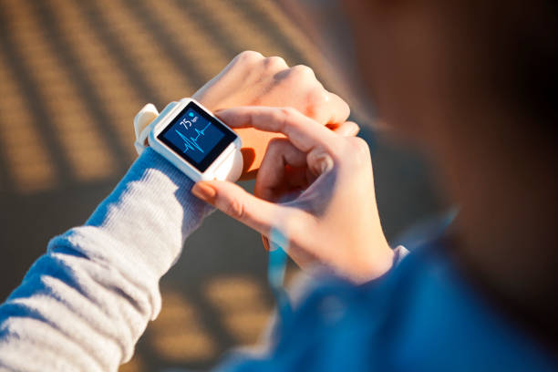 Checking Her Heart Rate on a smart watch Checking Her Heart Rate pulse trace stock pictures, royalty-free photos & images