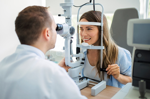Beautiful young girl checking the eye vision in modern ophthalmology clinic