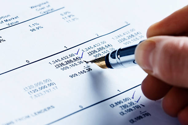 Checking the finances; man's hand marks off spreadsheet figures A man's hand uses a fountain pen to put check marks next to figures on a spreadsheet.  iridium stock pictures, royalty-free photos & images