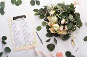 Planning wedding. Checklist with main items, roses bouquet and golden rings on white background