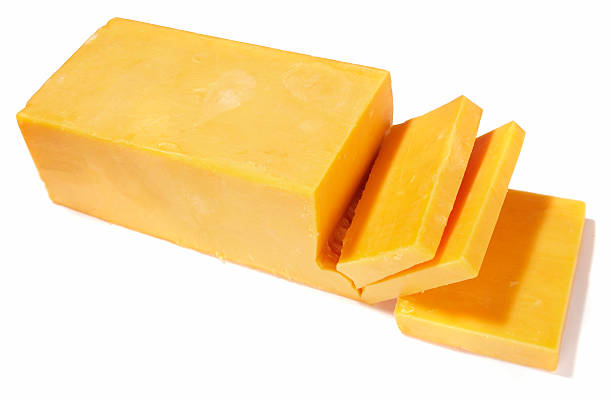 Cheddar cheese being cut on white background A block of sliced cheddar cheese isolated on white cheddar cheese stock pictures, royalty-free photos & images
