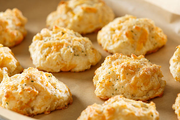 Cheddar Cheese Biscuits Fresh From the Oven Cheddar Cheese Biscuits on baking sheet cheddar cheese stock pictures, royalty-free photos & images