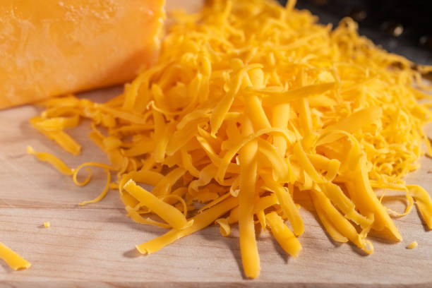 Chedder Cheese Grated on a Cutting Board stock photo