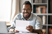 Cheerful african american male entrepreneur read great news in letter
