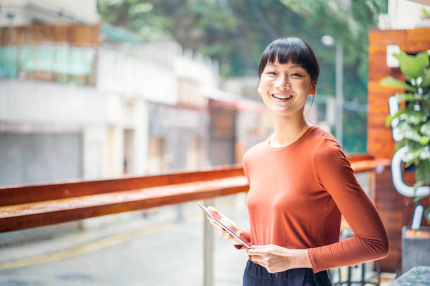 Cheerful Asian businesswoman holding a digital tablet stock photo