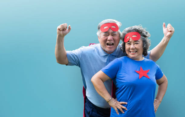 Cheerful Asian Senior couple wearing superhero costume stock photo