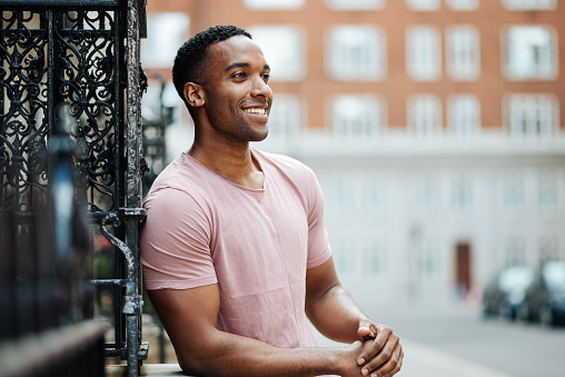 Portrait of handsome young man in London, wearing casual clothing and expressing positive emotions on the street