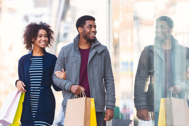 glada svarta älskare går nedför gatan - shopping center bildbanksfoton och bilder