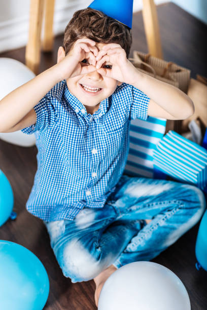 cheerful boy imitating binoculars with his hands - foster home bag imagens e fotografias de stock