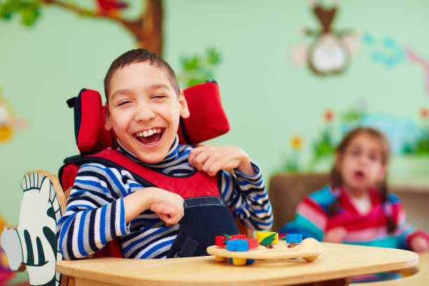 cheerful boy with disability at rehabilitation center for kids with special needs stock photo