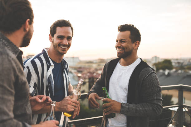 Cheerful friends enjoying at rooftop party stock photo